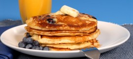 Blueberry pancakes with maple syrup and orange juice