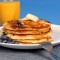 Blueberry pancakes with maple syrup and orange juice