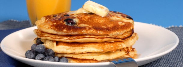 Blueberry pancakes with maple syrup and orange juice